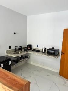 a white kitchen with a sink and a stove at Pé na Areia in Guarapari