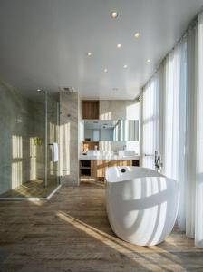 Hotel Mapp في تايتشونغ: حمام مع حوض استحمام أبيض كبير ودش