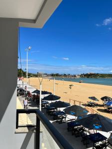 a beach with tables and chairs and umbrellas at Pé na Areia in Guarapari