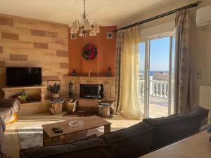 a living room with a couch and a large window at Villa Dreamy View in Agia Ermioni