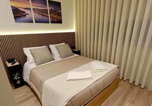 a bedroom with a bed with two towels on it at Feel Porto in Bolhão "Metro at your doorstep" in Porto
