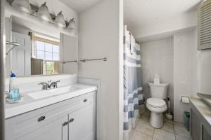 a white bathroom with a sink and a toilet at Downingtown Manor - 1900s Farmhouse with Creek Views in Downingtown +43 photos