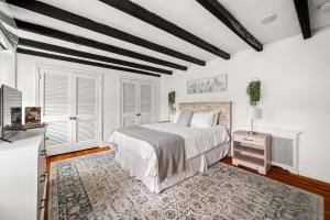 a bedroom with white walls and a bed and a rug at Downingtown Manor - 1900s Farmhouse with Creek Views in Downingtown