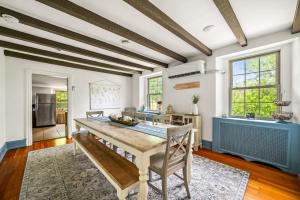 a dining room with a table and a kitchen at Downingtown Manor - 1900s Farmhouse with Creek Views in Downingtown