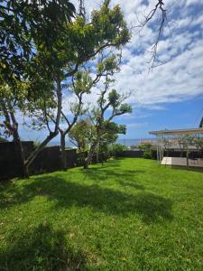 een grasveld met bomen en een gebouw bij Maja Hzari in Densainagar