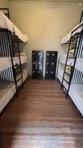three bunk beds in a room with wooden floors at A la Gurda Hostel - Barrio Sur in San Miguel de Tucumán