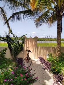 een fiets geparkeerd naast een hek met bloemen bij Résidence Diamane Sokone in Sokone