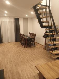 une salle à manger avec une table et des chaises ainsi qu'un escalier en colimaçon dans l'établissement Letnisko, à Lubawka