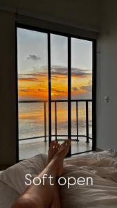 een persoon die op een bed ligt en uitkijkt op de oceaan bij Maraga Bento in Maragogi