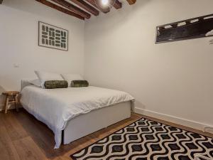 Schlafzimmer mit einem Bett mit einem schwarzen und weißen Teppich in der Unterkunft Studio cœur de Chartres, à côté de la cathédrale in Chartres