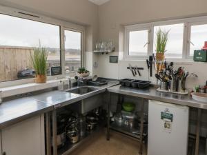 a kitchen with a sink and a counter at The Boat House - Port Eynon in Swansea