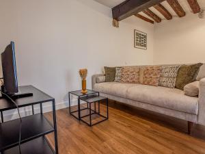 ein Wohnzimmer mit einer Couch und zwei Tischen in der Unterkunft Studio cœur de Chartres, à côté de la cathédrale in Chartres