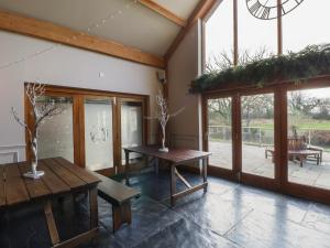 a room with a table and benches and windows at The Family Pod - Gower in Swansea +6 photos