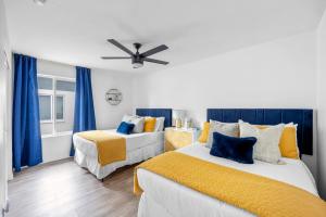 two beds in a room with blue curtains at Private Pool Haven Backyard & Putting Green in Phoenix +23 photos