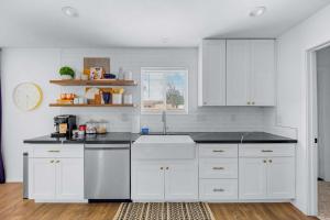 a kitchen with white cabinets and a sink at Private Pool Haven Backyard & Putting Green in Phoenix