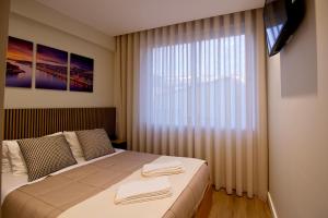 a bedroom with a bed and a large window at Feel Porto in Bolhão "Metro at your doorstep" in Porto