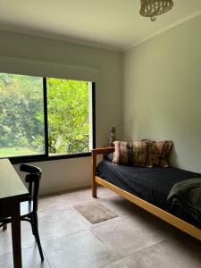 een slaapkamer met een bed en een groot raam bij Casa La Azulita in Lobos