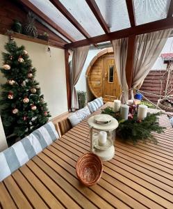 een houten tafel met een kerstboom op een terras bij Dora Holiday House & Apartments in Keszthely