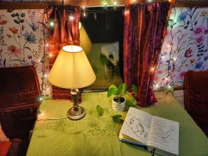 a table with a lamp and a book on it at The Wonderly Wagon in Fintown