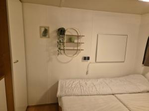 a bedroom with a bed and a wreath on the wall at Boshuisje in Nutter