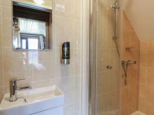 a bathroom with a shower and a sink at Glamping Tri Pod 7 - Gower in Swansea