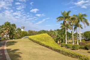 Un parque con palmeras y una torre de reloj al fondo. en Duyu Hotel 都寓酒店公寓, en Xiamen