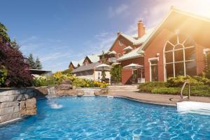 a house with a swimming pool in front of a house at Auberge Godefroy in Bécancour