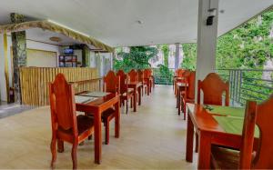 een eetkamer met houten tafels en stoelen bij El Nido Viewdeck Cottages in El Nido