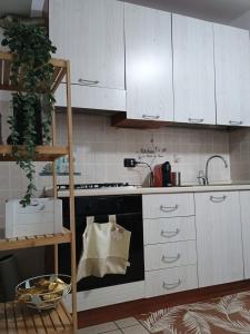 a kitchen with white cabinets and a black stove top oven at La villetta 2.0 in Rende