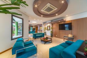 Hotel Laghetto Viale في غرامادو: غرفة معيشة مع أرائك زرقاء وتلفزيون