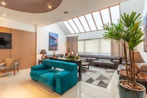 Hotel Laghetto Viale في غرامادو: غرفة معيشة مع كرسي أزرق وأريكة