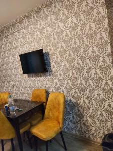una stanza con un tavolo e una TV su una parete di Apartament Gya a Lupeni