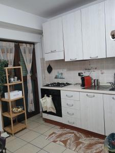 eine Küche mit weißen Schränken und einem Herd mit Backofen in der Unterkunft La villetta 2.0 in Rende + 8 Fotos