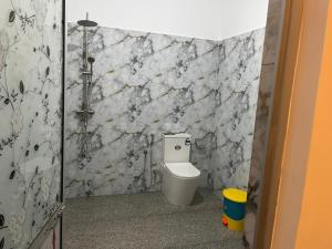 a bathroom with a toilet and a stone wall at Lio Villa in Habaraduwa Central +40 photos