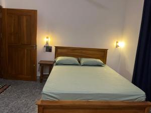 a bedroom with a bed with a wooden headboard and a door at Lio Villa in Habaraduwa Central