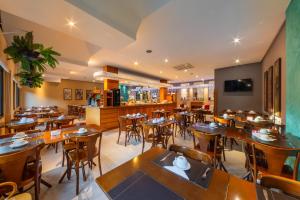 Hotel Laghetto Viale في غرامادو: مطعم به طاولات وكراسي وبار +33 صورة