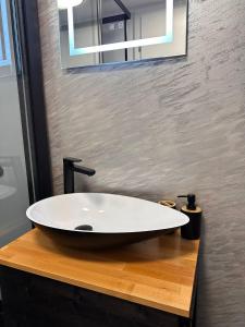 ein weißes Waschbecken auf einer Holztheke im Bad in der Unterkunft MR Tiny House - Private Parking in Roşu