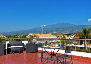 a patio with a table and chairs on a balcony at Le Ville della Contea -Vacation rentals in Mascali