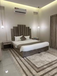 una camera con un grande letto e un tappeto di شاليهات روز a Al Shafa