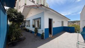 ein blau-weißes Gebäude mit Pflanzen darauf in der Unterkunft Casa Pet Friendly c 3 Quartos e Garagem no Jardim in Poços de Caldas