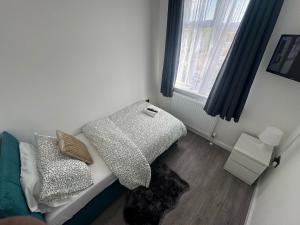une petite pièce avec un lit et une fenêtre dans l'établissement BXH B4 Cozy single room Bexleyheath, à Bexleyheath