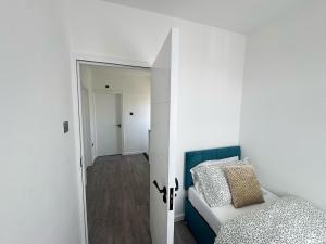 une chambre avec un lit et une porte donnant sur un couloir dans l'établissement BXH B4 Cozy single room Bexleyheath, à Bexleyheath