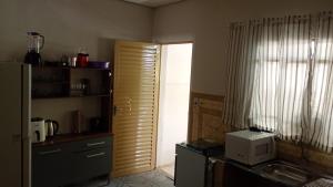 eine Küche mit Spüle und Mikrowelle in der Unterkunft Casa a 1 Minuto da basilica in Aparecida