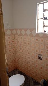 ein Badezimmer mit Toilette und Fenster in der Unterkunft Casa a 1 Minuto da basilica in Aparecida