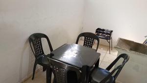 ein Zimmer mit 2 Stühlen und einem Tisch mit einem Herd in der Unterkunft Casa a 1 Minuto da basilica in Aparecida + 3 Fotos