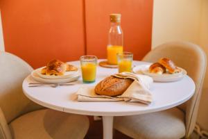 a table with plates of food and glasses of orange juice at Le Chéron - Confort, Wi-Fi & commerces à deux pas in Caen +7 photos