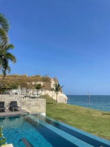 a swimming pool with a view of the ocean at Ideal home to relax and enjoy with family in El Nance