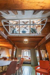 a room with a table and chairs and a ceiling at Gîte insolite in Nuits-Saint-Georges