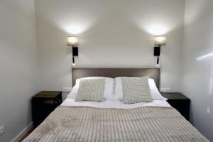 une chambre avec un lit avec deux tables de nuit et deux lampes dans l'établissement Corno Woda Apartamenty, à Jaworki