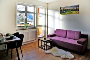 un salon avec un canapé violet et une table dans l'établissement Corno Woda Apartamenty, à Jaworki